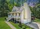 Home's side angle shows a two-car garage, a deck, and a well-maintained yard with mature trees at 411 Hollis Cir, Dallas, GA 30157