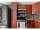 Cozy kitchen featuring stainless appliances, warm wood cabinetry, and granite countertops for functionality at 411 Hollis Cir, Dallas, GA 30157