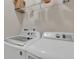 Bright laundry room with modern white appliances and overhead wire rack shelf at 4567 Hickory Forest Nw Dr, Acworth, GA 30102