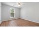 Bright bedroom featuring a ceiling fan, wood-look flooring, a window and neutral paint at 525 Forest Pl, Roswell, GA 30076