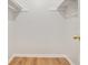 Empty walk-in closet featuring built-in shelving and hardwood flooring at 525 Forest Pl, Roswell, GA 30076