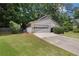 Side view of a well-maintained house, showcasing the two-car garage and green lawn at 525 Forest Pl, Roswell, GA 30076