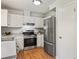 Modern kitchen with stainless steel appliances, white cabinets, and hardwood flooring at 525 Forest Pl, Roswell, GA 30076