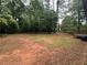 A large, expansive backyard with mature trees and partial fencing, ideal for outdoor activities and privacy at 595 Crowell Rd, Porterdale, GA 30014