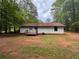 The backyard features a small deck, some trees, and an air conditioning unit at 595 Crowell Rd, Porterdale, GA 30014