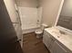 A bathroom is equipped with a shower-tub combo, toilet, and a vanity with a mirror, and vinyl floors at 595 Crowell Rd, Porterdale, GA 30014