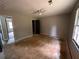 A bedroom includes a ceiling fan, a window for natural light, a closet, and unfinished flooring at 595 Crowell Rd, Porterdale, GA 30014