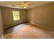 A bedroom features a ceiling fan, and one small window providing natural light, and the flooring is unfinished at 595 Crowell Rd, Porterdale, GA 30014
