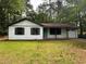Charming home with white siding, dark shutters, a covered porch, and an attached garage, surrounded by a green lawn at 595 Crowell Rd, Porterdale, GA 30014