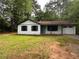 Charming single-story home with a well-maintained lawn and mature trees at 595 Crowell Rd, Porterdale, GA 30014