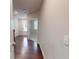 Hallway with hardwood floors leading to a doorway and staircase, offering seamless transitions at 753 Topsail Ln, Alpharetta, GA 30005