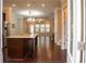 Open kitchen with dark wood island, pendant lighting and hardwood flooring that opens to the living room at 753 Topsail Ln, Alpharetta, GA 30005