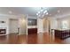 Open-concept living space with hardwood floors, a fireplace, built-in cabinetry, and a modern chandelier at 753 Topsail Ln, Alpharetta, GA 30005