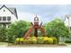 Outdoor view of decorative sculpture on landscaped traffic island with new homes in the background at 753 Topsail Ln, Alpharetta, GA 30005