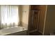 Well-lit bathroom with a large soaking tub and a separate glass-enclosed shower at 1481 Park Knoll Trl, Lawrenceville, GA 30043