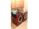 Functional laundry room with red front-loading washer and dryer, and overhead cabinets at 1481 Park Knoll Trl, Lawrenceville, GA 30043