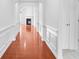 Hallway featuring hardwood floors, white molding, and an arched doorway that leads to a room with a fireplace at 1544 Overview Cir, Lawrenceville, GA 30044