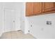 Practical laundry room with tiled floor, cabinets, and utility connections at 1544 Overview Cir, Lawrenceville, GA 30044