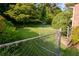 Lush backyard with tall trees and green grass, enclosed by a chain link fence at 3407 Larch Pine Dr, Duluth, GA 30096