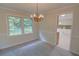 Well-lit dining room featuring an elegant chandelier and views of the private backyard at 3407 Larch Pine Dr, Duluth, GA 30096