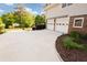 Side view of the home with a two-car garage and ample driveway space at 3407 Larch Pine Dr, Duluth, GA 30096