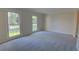 Bright living room with neutral paint, carpet flooring, and large windows at 3407 Larch Pine Dr, Duluth, GA 30096