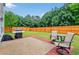 Cozy backyard patio with grill and chairs, perfect for outdoor entertaining in the fenced yard at 408 Sam Cobb Ct, Woodstock, GA 30188
