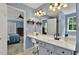 Stylish bathroom boasts a vanity with a large mirror, attractive lighting, and access to the main bedroom at 408 Sam Cobb Ct, Woodstock, GA 30188