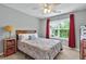 Bright bedroom featuring a ceiling fan, light gray walls, and window with red curtains at 408 Sam Cobb Ct, Woodstock, GA 30188