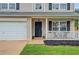 Close-up of a charming front porch with black door, white railing, and manicured landscaping at 408 Sam Cobb Ct, Woodstock, GA 30188