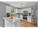 Bright, modern kitchen with white cabinetry, stainless appliances, and breakfast bar area at 408 Sam Cobb Ct, Woodstock, GA 30188