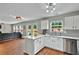 Modern kitchen with white cabinets, stainless steel appliances, and view of the living area at 408 Sam Cobb Ct, Woodstock, GA 30188