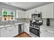 Modern kitchen featuring white cabinets, stainless steel appliances, and quartz countertops at 408 Sam Cobb Ct, Woodstock, GA 30188
