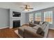 Cozy living room featuring a fireplace, TV, ceiling fan, and comfortable seating arrangement at 408 Sam Cobb Ct, Woodstock, GA 30188
