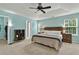 Main bedroom with a tray ceiling, ceiling fan, windows, and an ensuite bathroom at 408 Sam Cobb Ct, Woodstock, GA 30188