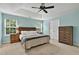 Main bedroom featuring a tray ceiling, ceiling fan, windows and ample closet space at 408 Sam Cobb Ct, Woodstock, GA 30188