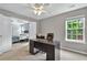 Home office with a large window, ceiling fan, and views into the main bedroom at 408 Sam Cobb Ct, Woodstock, GA 30188