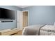 Bedroom features light blue walls, a bed with grey bedding, and a TV mounted on the wall at 6209 Benbrooke Dr, Acworth, GA 30101