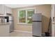 Bright kitchenette with stainless steel appliances, white cabinets and a window overlooking the yard at 6209 Benbrooke Dr, Acworth, GA 30101