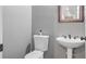 Well-lit powder room features a toilet, pedestal sink, and classic decorative mirror at 6209 Benbrooke Dr, Acworth, GA 30101