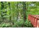 Lush backyard view with mature trees, a pond, and a wooden deck at 1647 Tunbridge Ln, Lawrenceville, GA 30043