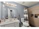 Bathroom featuring a shower-tub combo, modern vanity, and tiled shower with recessed shelves at 1647 Tunbridge Ln, Lawrenceville, GA 30043