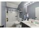 Cozy bathroom featuring a shower-tub combo, modern vanity, and decorative shelving for storage at 1647 Tunbridge Ln, Lawrenceville, GA 30043