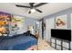 Modern bedroom with tile floors, a ceiling fan, neutral walls adorned with posters, and functional storage units at 1647 Tunbridge Ln, Lawrenceville, GA 30043