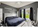 Comfortable bedroom with dark walls, floating shelves, and large window at 1647 Tunbridge Ln, Lawrenceville, GA 30043