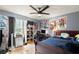 Inviting bedroom with cool-toned walls, tile floors, posters, a ceiling fan, and a dedicated study area at 1647 Tunbridge Ln, Lawrenceville, GA 30043