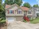 Lovely split-level home featuring a manicured lawn, a two-car garage, and mature trees at 1647 Tunbridge Ln, Lawrenceville, GA 30043
