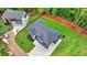 Aerial view of a house with a modern roof, a concrete driveway, and green landscaping at 165 Westbrook St, Buford, GA 30518