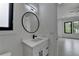 This modern bathroom has black hardware and a large round mirror at 165 Westbrook St, Buford, GA 30518