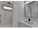 Bathroom vanity and shower with white marble tiling and black fixtures, with square mirror at 165 Westbrook St, Buford, GA 30518